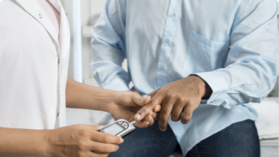 Man having blood sugar level checked by finger prick.